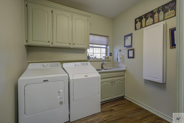 laundry room with cabinets, sink, dark hardwood / wood-style floors, and washing machine and clothes dryer