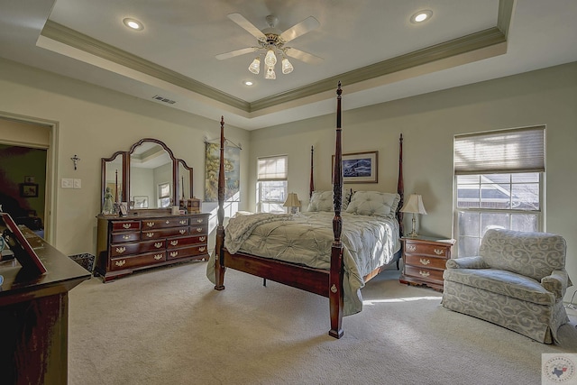 bedroom featuring ceiling fan, a raised ceiling, ornamental molding, and light carpet