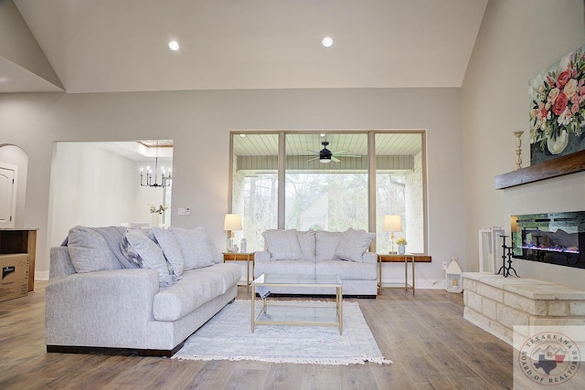 living room with lofted ceiling, hardwood / wood-style floors, and a notable chandelier