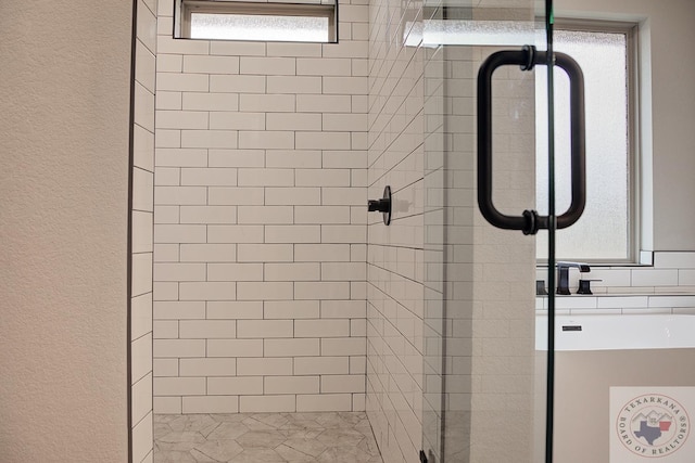 bathroom featuring a shower with door