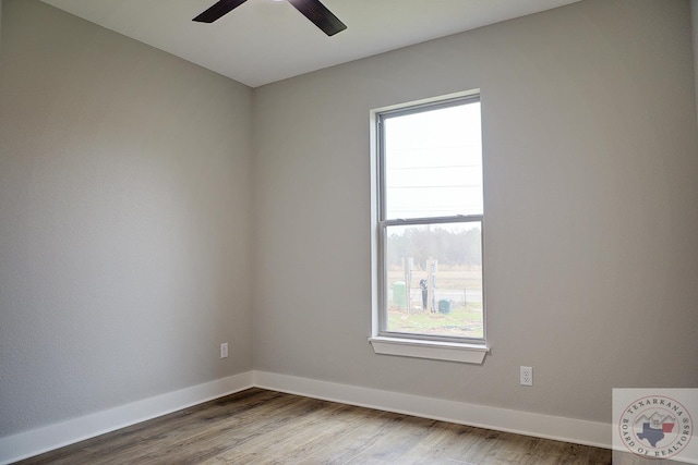 empty room with ceiling fan, hardwood / wood-style floors, and a wealth of natural light