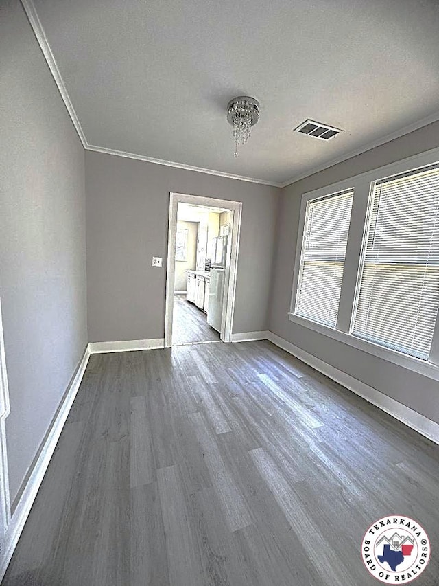 unfurnished dining area with baseboards, ornamental molding, dark wood-type flooring, and visible vents