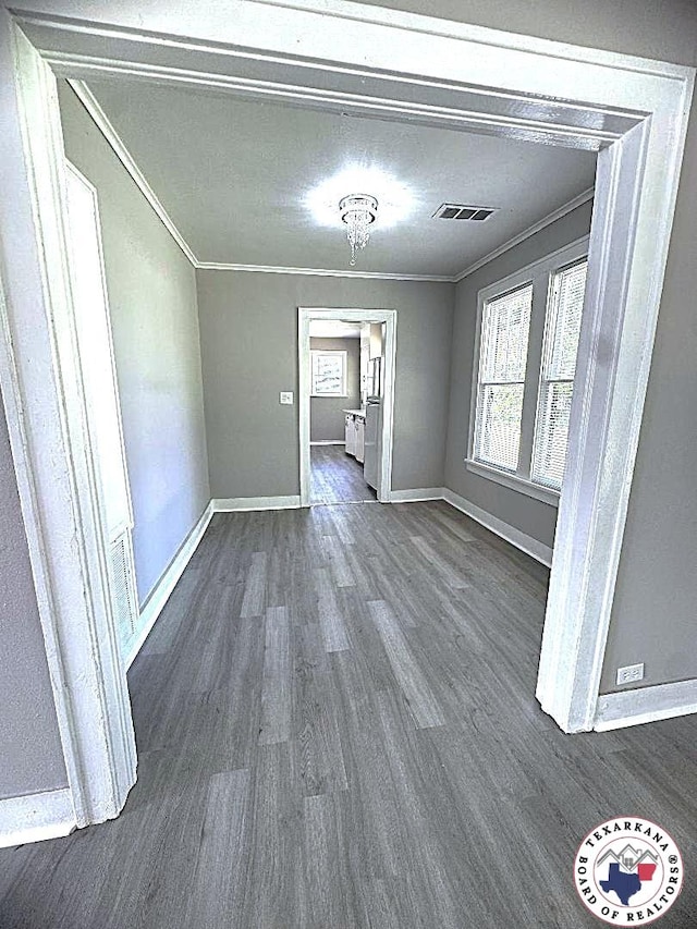unfurnished dining area with crown molding, baseboards, dark wood finished floors, and visible vents