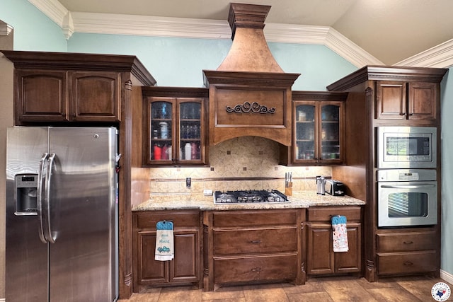 7 Coppercreek Cir, Texarkana, TX 75503 - kitchen featuring appliances with stainless steel finishes, decorative backsplash, dark brown cabinetry, ornamental molding, and light stone counters