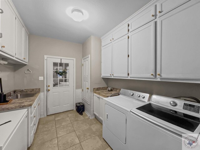 washroom featuring sink, light tile patterned floors, cabinets, and independent washer and dryer