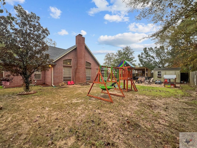 view of playground with a lawn and a storage shed