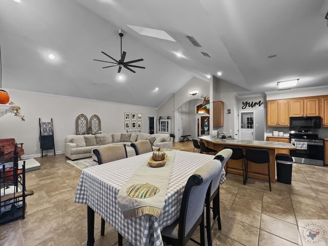 dining area featuring ceiling fan and lofted ceiling with skylight