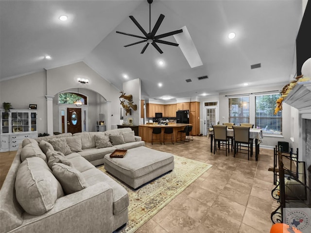 living room featuring ceiling fan, high vaulted ceiling, and ornate columns