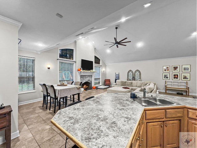 kitchen featuring ceiling fan, sink, light tile patterned floors, and ornamental molding