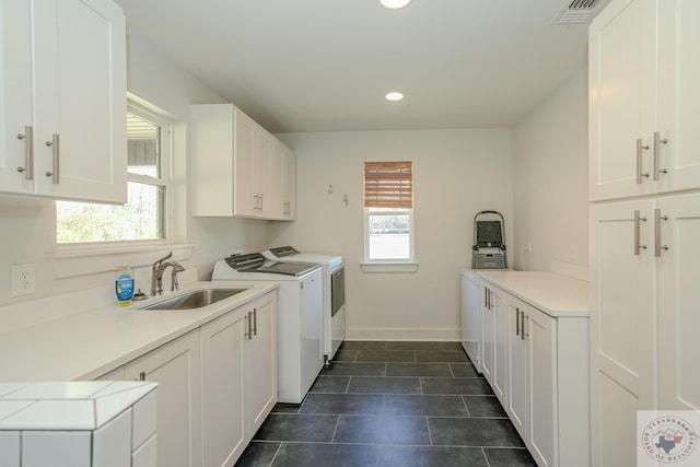 washroom with washing machine and dryer, plenty of natural light, a sink, and cabinet space