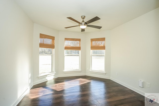 unfurnished room with plenty of natural light, dark wood-type flooring, and ceiling fan