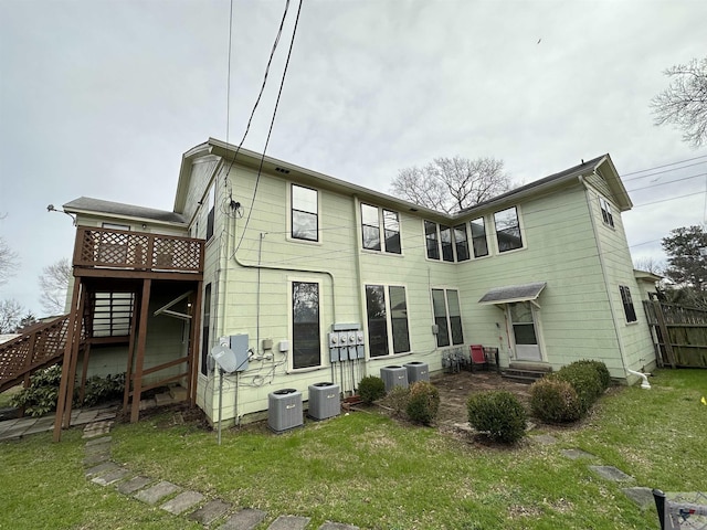 back of property featuring a lawn and central AC