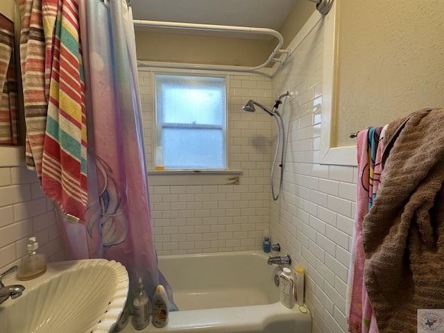 bathroom with sink, shower / bath combo, and tile walls