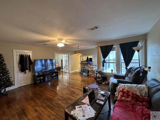 living room featuring ceiling fan, wood-type flooring, and a textured ceiling