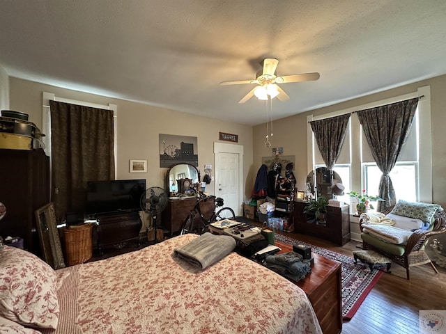 bedroom with ceiling fan, a textured ceiling, and hardwood / wood-style flooring