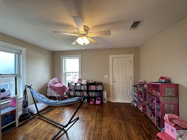 game room featuring dark wood-type flooring and ceiling fan