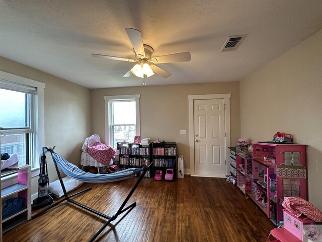 game room featuring dark wood-type flooring and ceiling fan