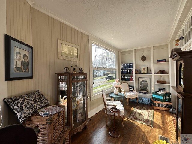 sitting room with a textured ceiling, dark hardwood / wood-style floors, and ornamental molding