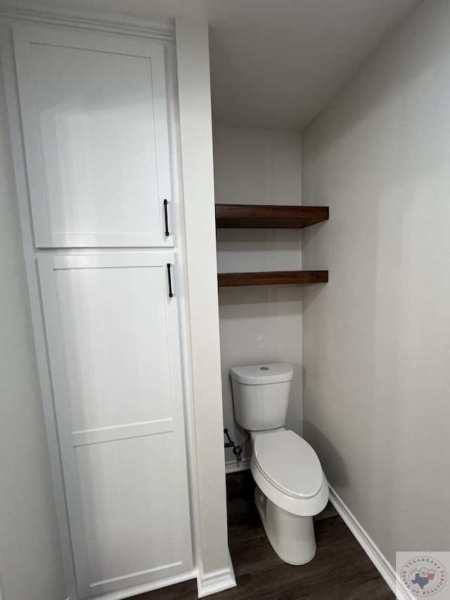 bathroom with toilet, wood finished floors, and baseboards