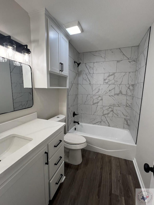 bathroom with toilet, shower / bath combination, vanity, wood finished floors, and a textured ceiling