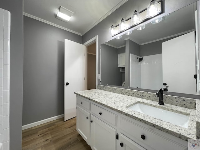 bathroom with a shower, hardwood / wood-style floors, vanity, and ornamental molding