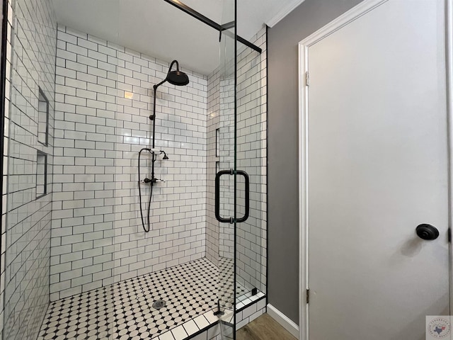 bathroom featuring wood-type flooring, an enclosed shower, and ornamental molding