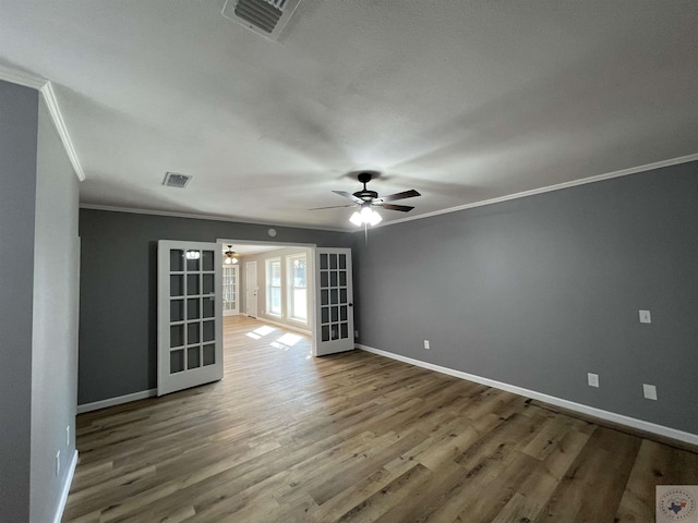 spare room featuring ornamental molding, hardwood / wood-style floors, ceiling fan, and french doors