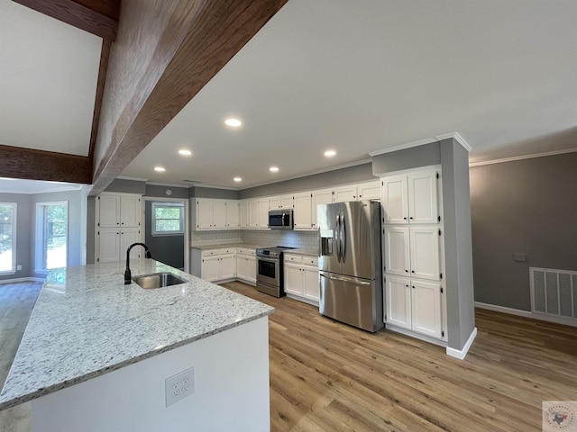 kitchen featuring white cabinetry, sink, light hardwood / wood-style flooring, stainless steel appliances, and light stone counters