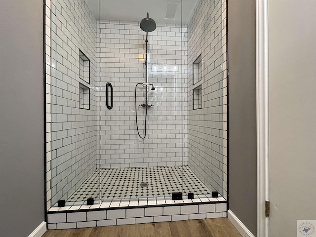 bathroom featuring a shower with shower door and hardwood / wood-style floors