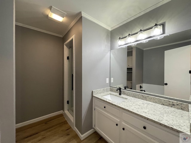 bathroom featuring vanity, hardwood / wood-style flooring, crown molding, and a shower with shower door