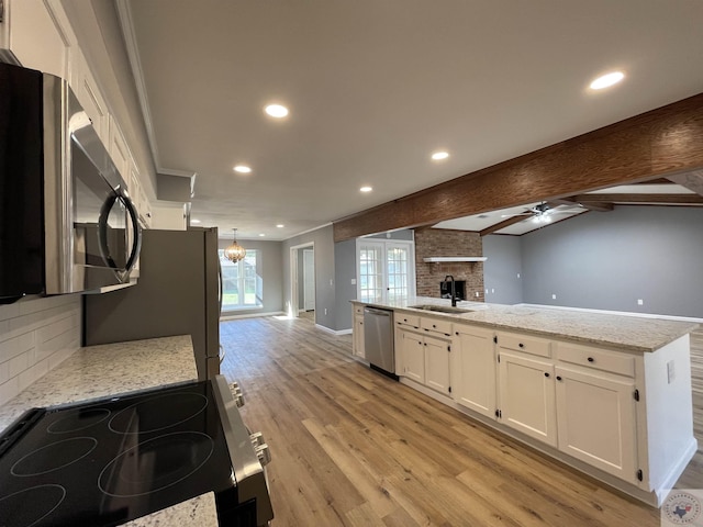 kitchen with light stone countertops, white cabinetry, beam ceiling, backsplash, and stainless steel appliances