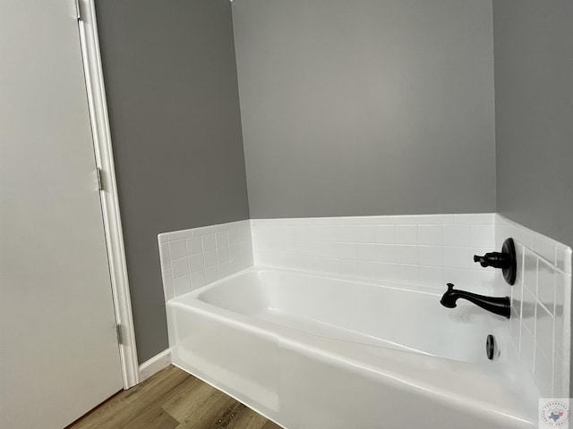 bathroom featuring wood-type flooring and a bathing tub