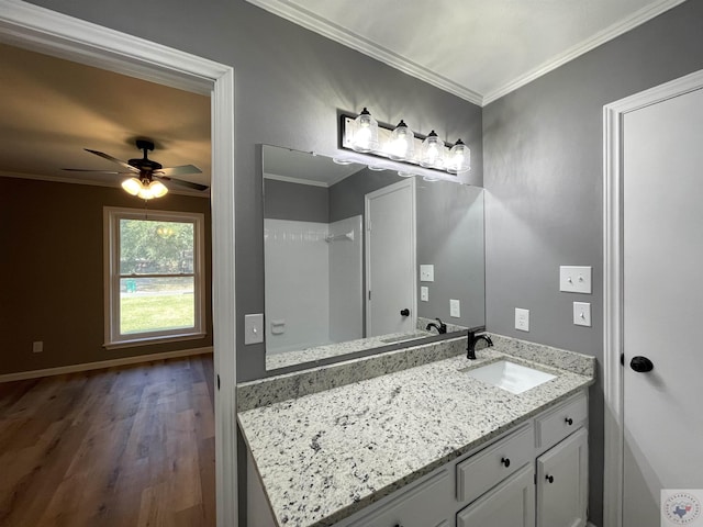 bathroom with crown molding, hardwood / wood-style floors, ceiling fan, and vanity