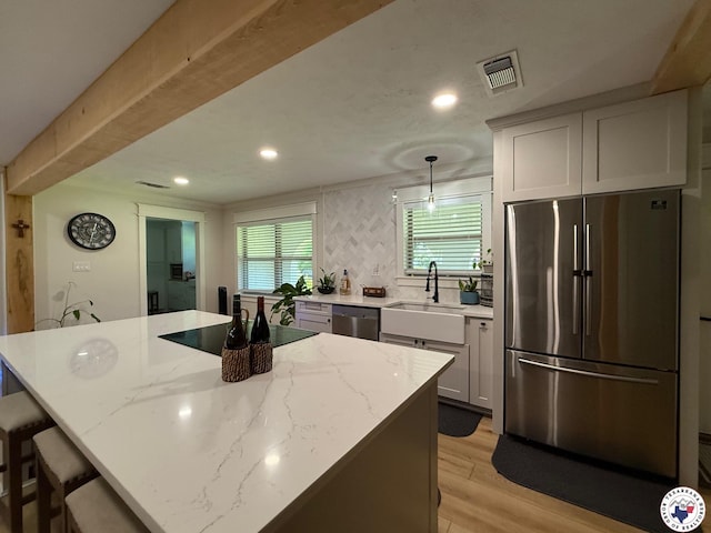 206 Oak St, New Boston, TX 75570 - kitchen with stainless steel appliances, a sink, recessed lighting, light wood finished floors, and light stone counters