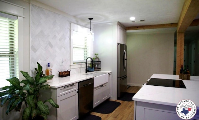 206 Oak St, New Boston, TX 75570 - kitchen with dishwashing machine, freestanding refrigerator, light wood-style floors, light countertops, and a sink