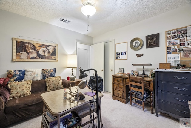 carpeted home office featuring a textured ceiling