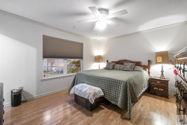 bedroom with ceiling fan, ornamental molding, light hardwood / wood-style floors, and a textured ceiling