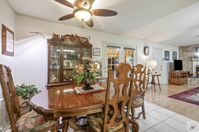 tiled dining room with a textured ceiling and ceiling fan