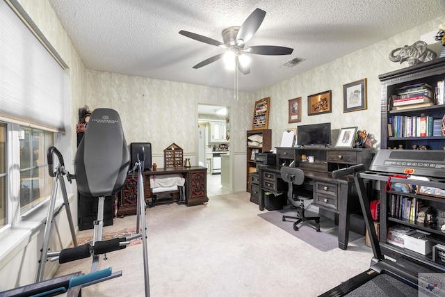 home office with a textured ceiling, carpet flooring, and ceiling fan