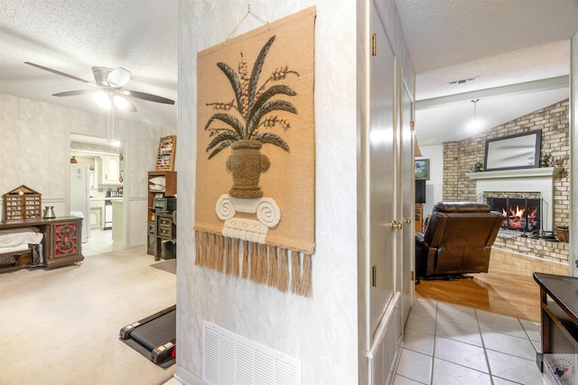 hallway featuring vaulted ceiling, tile patterned floors, and a textured ceiling