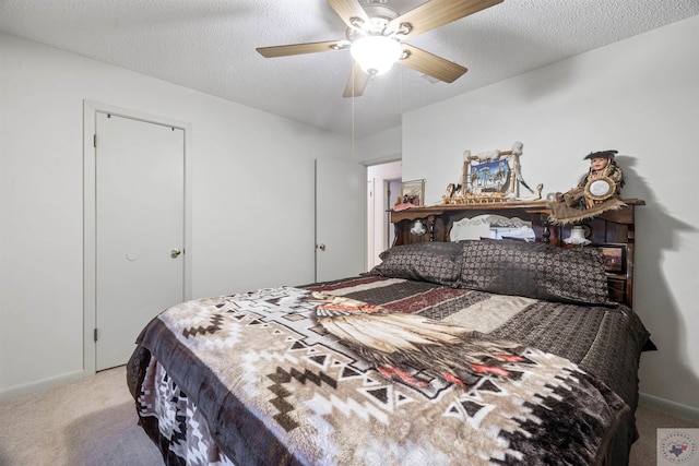 carpeted bedroom featuring a textured ceiling and ceiling fan