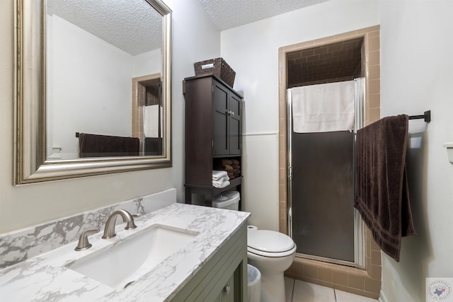 bathroom featuring a shower with shower door, toilet, a textured ceiling, tile patterned floors, and vanity