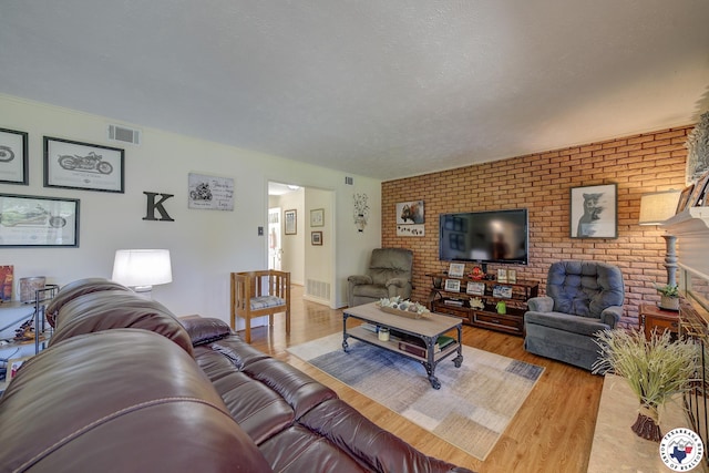 1302 Canadian St, Texarkana, TX 75503 - living room featuring wood finished floors and brick wall