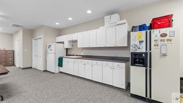 7207 N Richland Dr, Texarkana, TX 75503 - kitchen with dark countertops, visible vents, white refrigerator with ice dispenser, freestanding refrigerator, and a sink