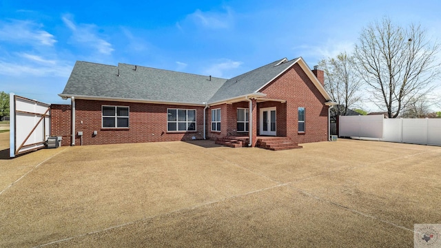 7207 N Richland Dr, Texarkana, TX 75503 - rear view of house with entry steps, a patio, fence, brick siding, and a chimney