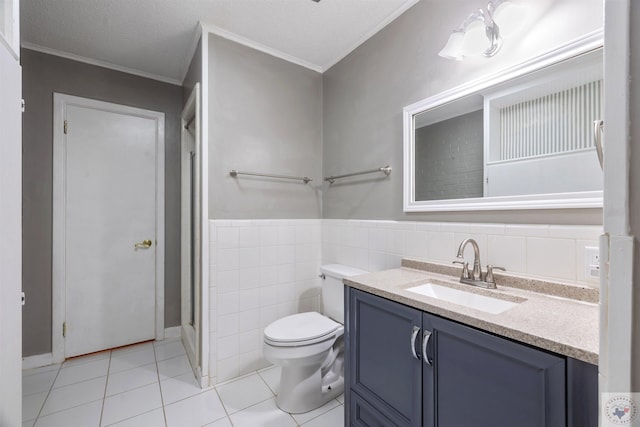 bathroom with toilet, tile walls, tile patterned flooring, ornamental molding, and vanity