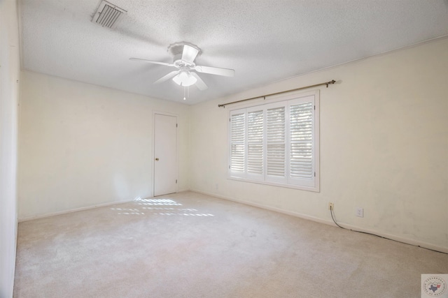 carpeted spare room with a textured ceiling and ceiling fan