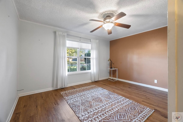 spare room with ceiling fan, crown molding, and wood-type flooring