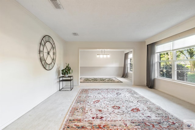 corridor featuring light carpet and an inviting chandelier