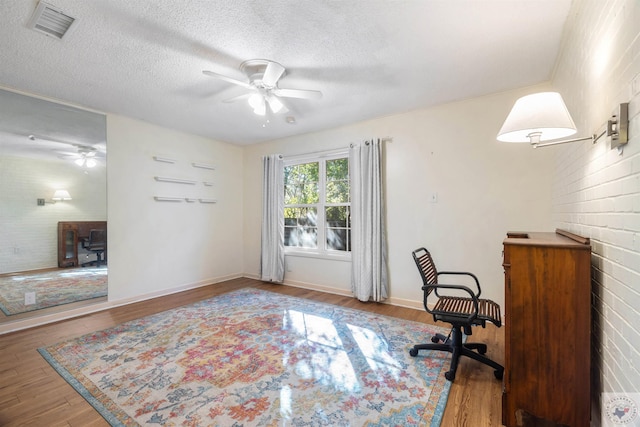 office space with hardwood / wood-style flooring, a textured ceiling, and ceiling fan